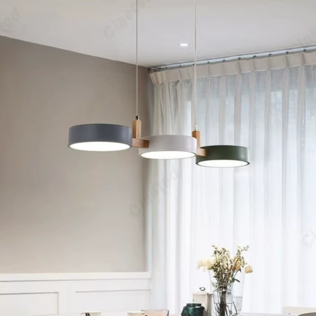 Three Scandinavian round pendant lights in grey, white and green hanging over a dining table - modern Nordic ceiling lights - Litora