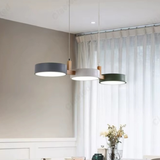 Three Scandinavian round pendant lights in grey, white and green hanging over a dining table - modern Nordic ceiling lights - Litora