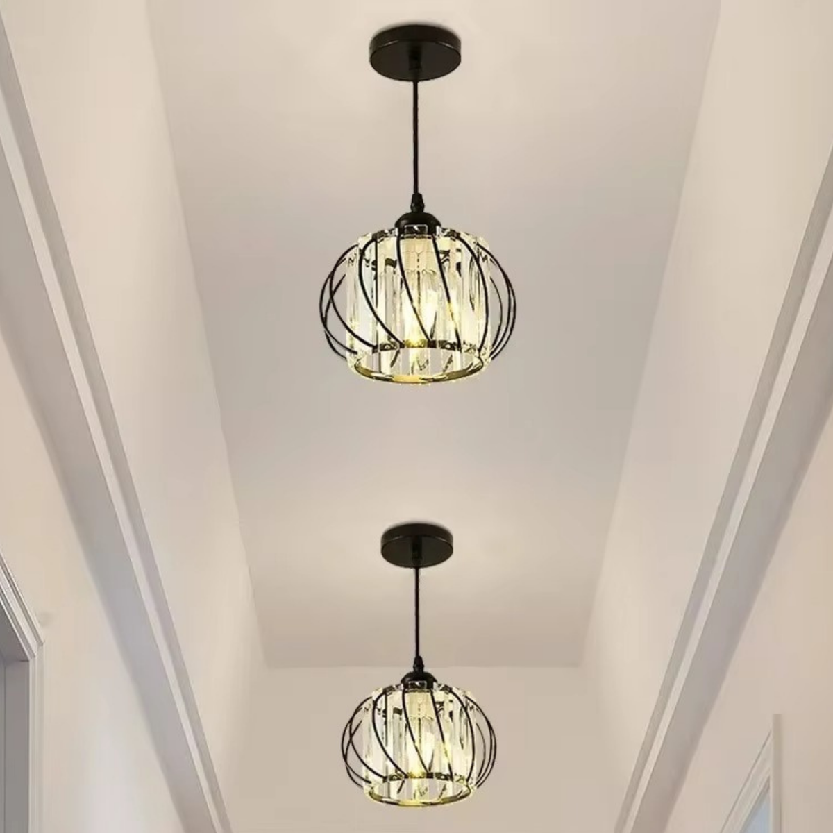 Two black spiral cage crystal pendant lights hanging at different heights in a bright modern hallway - decorative crystal ceiling light - Litora